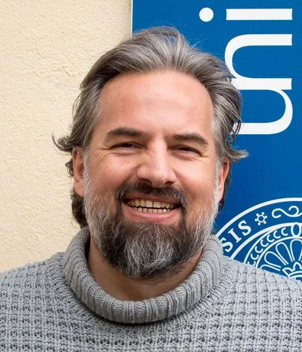Stefan M. Schneider vor dem Banner der Universität Wien